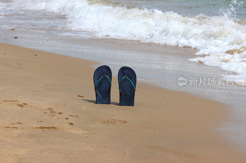 人字拖/丁字裤站在沙滩上，沙滩凉鞋